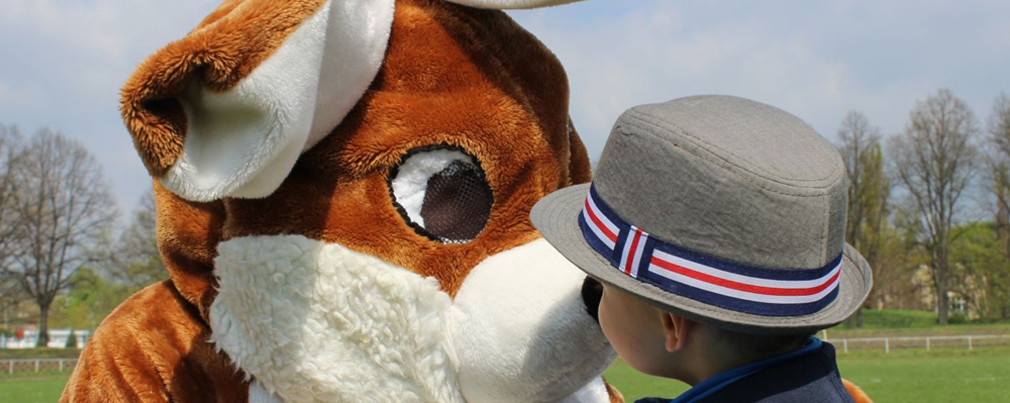 Ein Mensch in Hasenkostüm wird gerade von einem kleinen Jungen mit Hut angeschaut