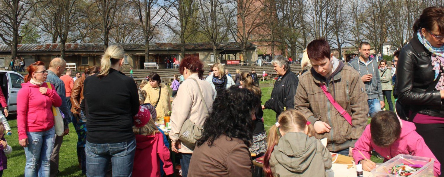 Mehrere Menschen stehen neben einer Bank, auf der Kinder malen