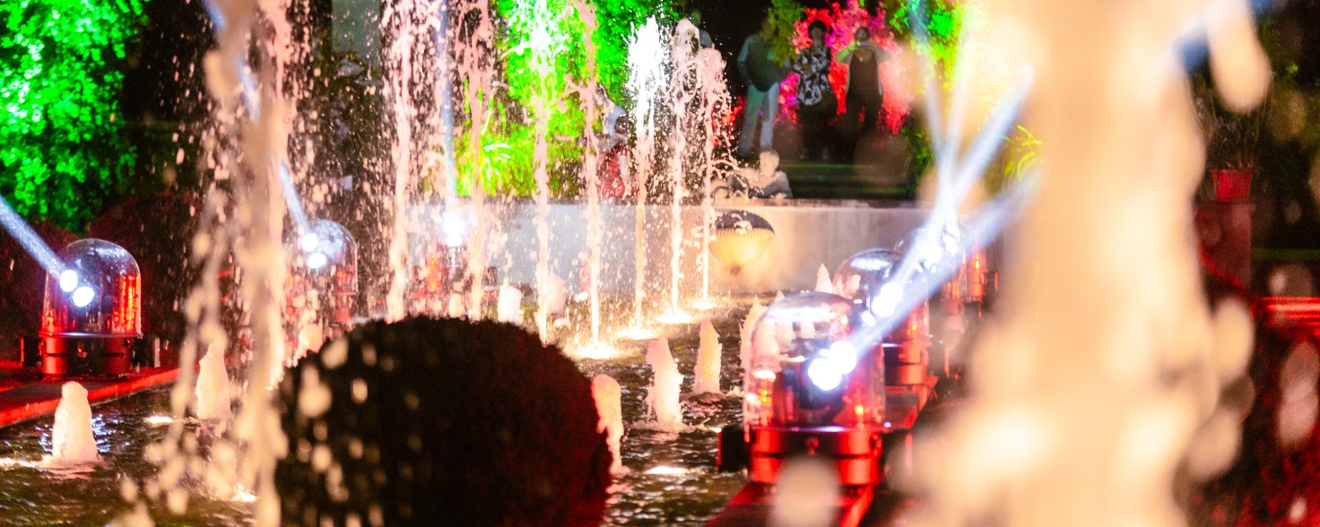 Ein bunt leuchtender Springbrunnen in Forst (Lausitz) am Abend