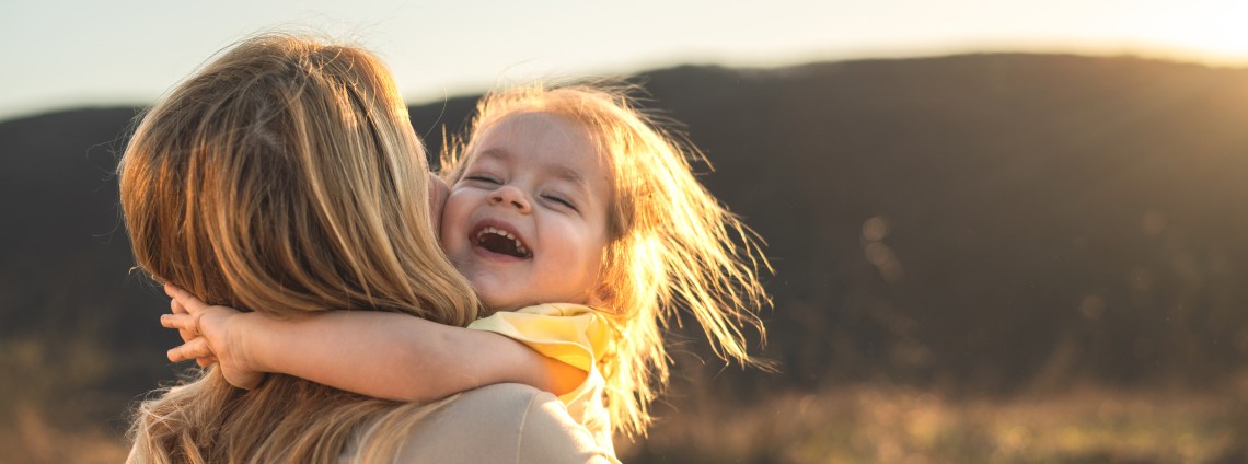 Eine Mutter mit Kind auf dem Arm in der Natur